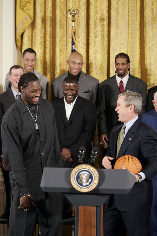 During a ceremony honoring the Detroit Pistons for winning the 2004 NBA Championship, President George W. Bush shares a laugh with basketball player Ben Wallace in the East Room, Jan. 31, 2005. White House photo by Paul Morse.