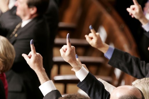 Members of Congress display purple ink-stained forefingers as a salute to voters in Sunday's Iraqi election, whose fingers were marked in a similar way, during President George W. Bush's State of the Union Address at the U.S. Capitol, Wednesday, Feb. 2, 2005. "We will succeed because the Iraqi people value their own liberty -- as they showed the world last Sunday," President Bush said. "Americans recognize that spirit of liberty, because we share it. In any nation, casting your vote is an act of civic responsibility; for millions of Iraqis, it was also an act of personal courage, and they have earned the respect of us all." White House photo by Paul Morse