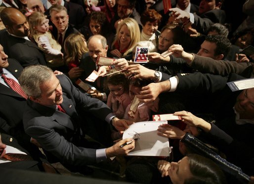 President George W. Bush autographs mementos after participating in a discussion on strengthening Social Security in Little Rock, Ark., Friday, Feb. 4, 2005. White House photo by Eric Draper