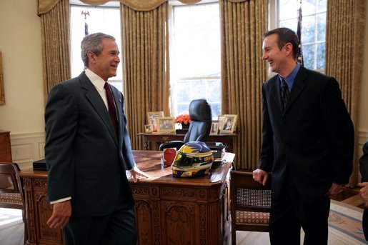 President George W. Bush talks with Kurt Busch, the 2004 Nextel Cup Nascar champion, during a visit by him and other racing officials to the Oval Office Feb. 7, 2005. President Bush was presented a racing helmet by Mr. Busch during the visit. White House photo by Eric Draper