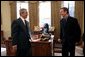 President George W. Bush talks with Kurt Busch, the 2004 Nextel Cup Nascar champion, during a visit by him and other racing officials to the Oval Office Feb. 7, 2005. President Bush was presented a racing helmet by Mr. Busch during the visit. White House photo by Eric Draper