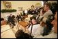 Surrounded by the members of the media, President George W. Bush greets Poland's President Aleksander Kwasniewski in the Oval Office Wednesday, Feb. 9, 2005. White House photo by Eric Draper