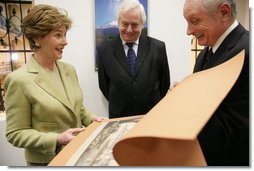 During the opening of University Library's "Info USA," Tibor Trgina, General Director of the library, shows Laura Bush books and artwork preserved at the library in Bratislava, Slovak Republic. Laura Bush was also joined by Slovak Republic's Minister of Culture Rudolf Chmel, center, during her visit to the library, Thursday, Feb. 24, 2005.  White House photo by Susan Sterner