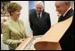 During the opening of University Library's "Info USA," Tibor Trgina, General Director of the library, shows Laura Bush books and artwork preserved at the library in Bratislava, Slovak Republic. Laura Bush was also joined by Slovak Republic's Minister of Culture Rudolf Chmel, center, during her visit to the library, Thursday, Feb. 24, 2005. White House photo by Susan Sterner