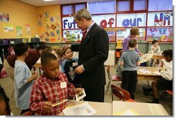 President George W. Bush talks with Kasey Stevenson and other students as he signs autographs during a visit to an after-school classroom program at the Providence Family Support Center in Pittsburgh Monday, March 7, 2005.   White House photo by Susan Sterner