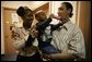 Kevion Thigpen, 3, held by his parents Kanyatta "Ken" Thigpen and his girlfriend Jewell Reed plays with a kaleidescope given to him by Laura Bush during a visit to the Rosalie Manor Community and Family Services center in Milwaukee, Wis., Tuesday, March 8, 2005. Citing a New York Times article by Jason DeParle Mrs. Bush credits Mr. Thigpen's determination to be a responsible father with bringing her attention to the needs of boys and young men. White House photo by Susan Sterner