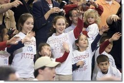 Wearing matching T-shirts, a group of future retirees wave during the President's visit to Shreveport, La., Friday, March 11, 2005. White House photo by Paul Morse