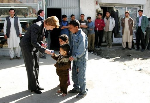 Laura Bush is greeted by youngsters outside a Kabul bakery during her visit Wednesday, March 30, 2005. The first lady presented White House red, white & blue kaleidoscopes to the children. White House photo by Susan Sterner