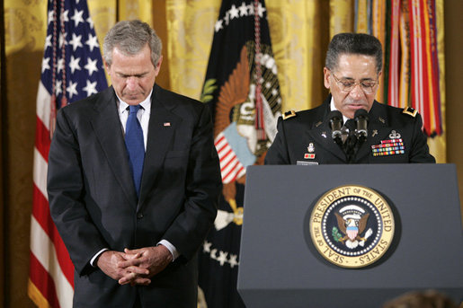 President Bush bows his head as Major General David Hicks, the Army Chief of Chaplains, delivers the invocation Monday, April 4, 2005, during a Medal of Honor ceremony honoring Sgt. 1st Class Paul Smith, killed in action during Operation Iraqi Freedom. White House photo by Eric Draper