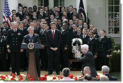 President George W. Bush and the Midshipmen of the U.S. Naval Academy's football team, break out in laughter as Sen. John McCain, R-Ariz., acknowledges his late arrival Wednesday, April 20, 2005, to the Rose Garden presentation of the Commander-in-Chief Trophy. The trophy is awarded after each season to the service academy with the best overall record against the other two. White House photo by Paul Morse