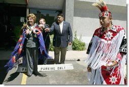 Laura Bush wears a traditional Native American wrap as she watches a musical performance before touring the Native American Community Health Center in Phoenix, Ariz., April 26, 2005.  White House photo by Krisanne Johnson