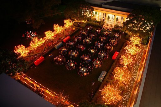 As night falls, the Rose Garden is filled with the glow of lighted trees as members of the Marine Band serenade President George W. Bush and Laura Bush and their guests during a dinner celebrating Cinco de Mayo Wednesday, May 4, 2005. White House photo by Paul Morse