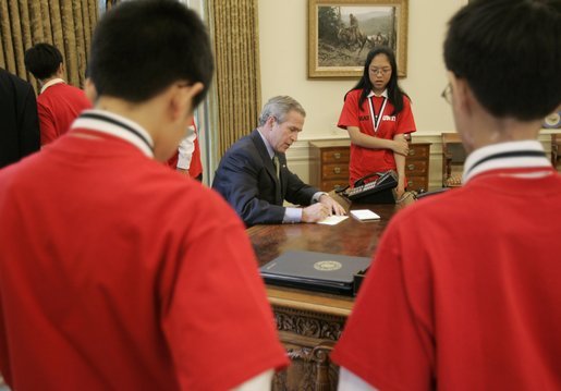 President George W. Bush signs notes to recipients of the 2005 MATHCOUNTS National Competition award during their visit to the Oval Office Thursday, May 12, 2005. White House photo by Paul Morse