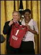 Ogonna Nnamani presents President George W. Bush with a team jersey from the Stanford University Women’s volleyball team during a ceremony celebrating the 2005 NCAA champions in the East Room Friday, May 13, 2005. White House photo by Eric Draper