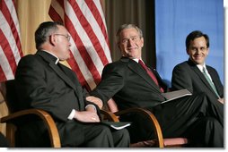 President George W. Bush reaches to Archbishop Charles J Chaput of Denver at the National Catholic Prayer Breakfast in Washington, D.C., Friday, May 20, 2005. Also pictured is Joseph Cella. White House photo by Eric Draper