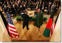 With the media looking on, President George W. Bush reaches out to shake hands with President Hamid Karzai of Afghanistan after a joint press availability Monday, May 23, 2005, in the East Room of the White House.  White House photo by Paul Morse