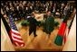 With the media looking on, President George W. Bush reaches out to shake hands with President Hamid Karzai of Afghanistan after a joint press availability Monday, May 23, 2005, in the East Room of the White House. White House photo by Paul Morse