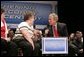 President George W. Bush talks with a fellow stage participant during a conversation about strengthening Social Security at Greece Athena Middle and High School in Greece, N.Y., Tuesday, May 24, 2005. White House photo by Paul Morse