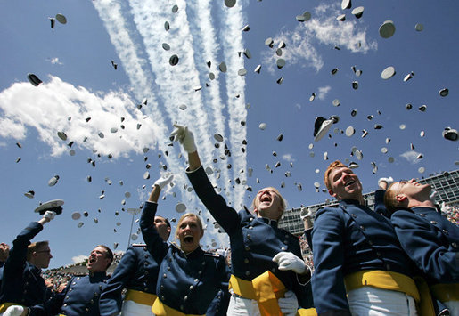 Graduates toss their hats into the air as the contrails from five F-16's stream overhead during the U.S. Air Force Academy graduation in Colorado on Wednesday, June 1, 2005. Nine-hundred and six graduates became commissioned officers in the U.S. Air Force after their four-year curriculum that began shortly before Sept. 11, 2001. White House photo by David Bohrer