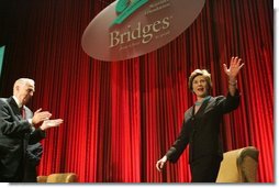 Laura Bush acknowledges the applause of the crowd as she is introduced at the Marriott Foundation for Disabilities Gala Dinner, June 14, 2005 at the Marriott Wardman Park Hotel in Washington, D.C. J.W. (Bill) Marriott, Jr., left, is seen welcoming Mrs. Bush to the podium.  White House photo by Krisanne Johnson