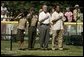 President George W. Bush is joined by Barry Larkin, White House Tee Ball Commissioner of the Game and Young Marines as they stand for the National Anthem Sunday, June 26, 2005, during "Tee Ball on the South Lawn." White House photo by Krisanne Johnson