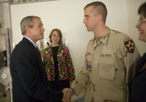 President George W. Bush shakes the hand of Capt. Daniel Gade, a double Purple Heart recipient, during the President's visit Friday, July 1, 2005, to Walter Reed Army Medical Center. The Minot, North Dakota soldier is recovering from injuries sustained during Operation Iraqi Freedom. In the background is his wife, Wendy. White House photo by Eric Draper