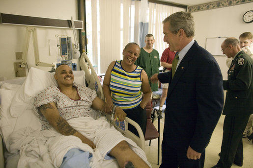 President George W. Bush shares a light moment with Sgt. John Iverson and his wife, Pamela, during the President's visit Friday, July 1, 2005, to Walter Reed Army Medical Center. The Long Beach, California soldier is recovering from injuries sustained while serving in Operation Iraqi Freedom. White House photo by Eric Draper