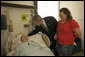 President George W. Bush pats the head of Pvt. 2nd Class Bart Tucker of Sioux City, Iowa, Friday, July 1, 2005, while his wife Heather looks on. The President visited the soldier at Walter Reed Army Medical Hospital, where he awarded Pvt. Tucker a Purple Heart for injuries received while serving in Operation Iraqi Freedom. White House photo by Eric Draper