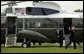 President George W. Bush waves as he and staff members arrive on the South Lawn Monday, July 11, 2005. White House photo by Lynden Steele