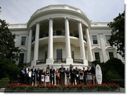 President Bush addresses an audience on the South Lawn, Tuesday, July 12, 2005, standing with the team representatives of the 2004 and 2005 NCAA Sport Championship teams being honored at the White House.  White House photo by Eric Draper