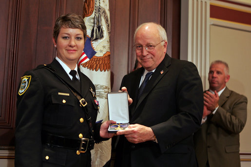 Vice President Dick Cheney awards Deputy Jennifer Fulford, of Florida's Orange County Sheriff's Office, the Public Safety Officer Medal of Valor Award Thursday, July 14, 2005, during a ceremony in the Dwight D. Eisenhower Executive Office Building. Deputy Fulford responded to a burglary in progress call May 5, 2004, after an 8-year-old boy called 911 so say that "strange men" were in his home with weapons and that he and his sister were hiding inside a van in the garage. Deputy Fulford entered the garage to check on the children, and two men emerged from the house firing their weapons. Deputy Fulford, trapped in the garage, returned fire. She was struck a total of ten times, including in her shooting hand. She was still able to retrieve her weapon with her other hand and continue firing until both gunmen went to the ground. The children were kept safe and unharmed throughout the incident. White House photo by David Bohrer