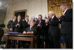 President George W. Bush acknowledges the applause of legislators and administration officials Tuesday, Aug. 2. 2005 in the East room of the White House, as he signs the CAFTA Implementation Act.  White House photo by Paul Morse