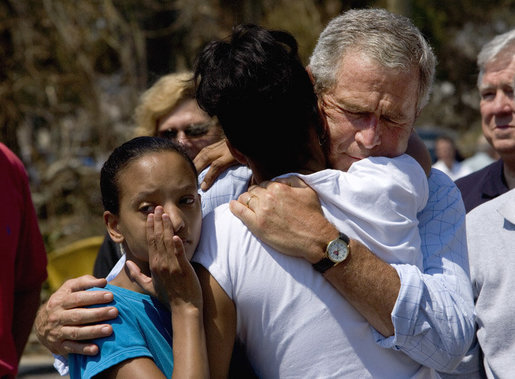 President George W. Bush comforts Bronwynne Bassier, right, and her sister Kim after landing in Biloxi, Miss., Friday Sept. 2, 2005, as part of his tour of the Hurricane Katrina-ravaged Gulf Coast. Their family lost everything in the wake of the devastating storm. White House photo by Eric Draper