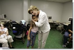 First Lady Laura Bush hugs a young girl displaced by Hurricane Katrina during her visit Friday, Sept. 2, 2005, to the Cajundome at the University of Louisiana in Lafayette. "Some things are working very, very well in Louisiana," Mrs. Bush said. "And certainly this center is one of those."  White House photo by Krisanne Johnson