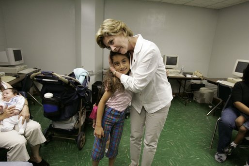 First Lady Laura Bush hugs a young girl displaced by Hurricane Katrina during her visit Friday, Sept. 2, 2005, to the Cajundome at the University of Louisiana in Lafayette. "Some things are working very, very well in Louisiana," Mrs. Bush said. "And certainly this center is one of those." White House photo by Krisanne Johnson