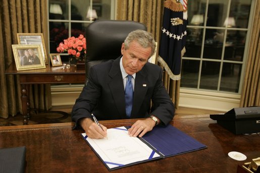 President George W. Bush signs legislation in the Oval Office Friday, Sept. 2, 2005, to provide 10.5 billion dollars in relief aid for the areas along the Gulf Coast affected by Hurricane Katrina. Congress approved the bill late Thursday. White House photo by Paul Morse