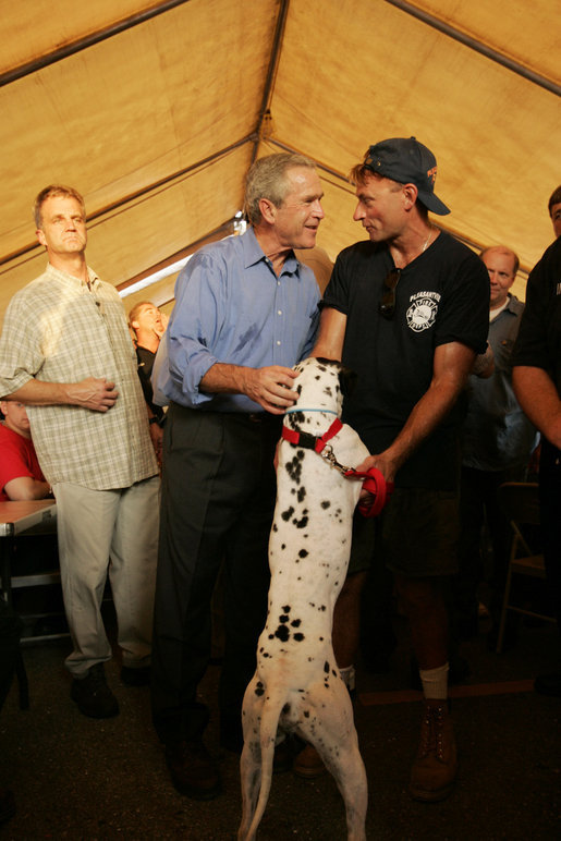 President Bush talks with firefighter Gary Garwood of Pleasantview, Ill., and Louie, who was rescued by Garwood, a first-responder in Hurricane Katrina's aftermath, and renamed for the state of Louisiana. The exchange came as the President visited a base camp in Algiers, La., Sunday, Sept. 11, 2005, during his return to the Gulf Coast. White House photo by Paul Morse