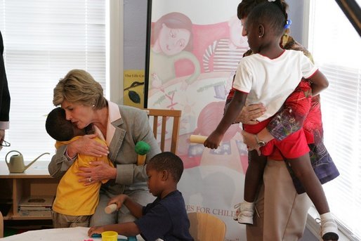 Mrs. Laura Bush receives a hug from a young boy at the House of Tiny Treasures in Houston during her visit Monday, Sept. 19, 2005. The House enables parents to search for jobs and housing, and to run errands while their children receive good care from credentialed teachers. White House photo by Krisanne Johnson