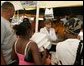 Laura Bush helps give out meals to families, while visiting a medical and food distribution site, Tuesday, Sept. 27, 2005 in Biloxi, Miss. White House photo by Krisanne Johnson