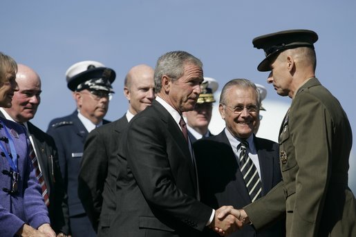 President George W. Bush congratulates U.S. Marine General Peter Pace, after Pace was sworn-in Friday, Sept. 30, 2005, as the new Chairman of the Joint Chiefs of Staff, at the Armed Forces Farewell Tribute in Honor of General Richard B. Myers and Armed Forces Hail in Honor of General Pace at Fort Myer in Ft. Myer, Va. Defense Secretary Donald Rumsfeld is seen center. White House photo by Shealah Craighead