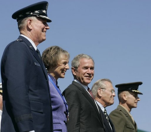 General Richard B. Myers, Mary Jo Myers, President George W. Bush, Secretary of Defense Donald Rumsfeld, and General Peter Pace, observe the March in Review, the Joint Service Medley and the Flyover during the Chairman of the Joint Chiefs of Staff change of command, Friday, Sept. 30, 2005, at The Armed Forces Farewell Tribute in Honor of General Richard B. Myers and Armed Forces Hail in Honor of General Peter Pace at Fort Myer's Summerall Field in Ft. Myer, Va. White House photo by Shealah Craighead