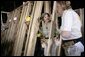 Laura Bush helps push a support wall into place, Tuesday, Oct. 11, 2005, while visiting a Habitat for Humanity building site in Covington, La., where homes are being built for victims of Hurricane Katrina. White House photo by Eric Draper