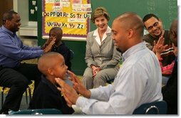 Laura Bush watches fathers play a game with their children in the R.E.A.D. to Kids Training Program at J.S. Chick Elementary School in Kansas City, Mo., Tuesday, October 11, 2005.  White House photo by Krisanne Johnson