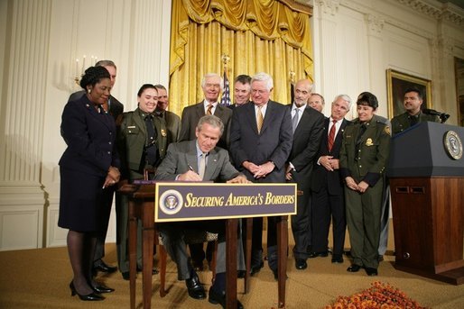 President George W. Bush is joined by legislators, cabinet members and law enforcement officials, Tuesday, Oct. 18, 2005 in the East Room of the White House, as he signs the Homeland Security Appropriations Act for fiscal year 2006. White House photo by Paul Morse