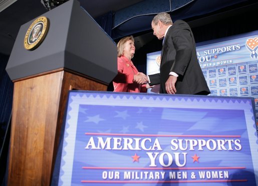 President George W. Bush shakes the hand of Jonnie Nance, chairman of the Joint Armed Forces Officers' Wives Luncheon, after being introduced by her Tuesday, Oct. 25, 2005, at the Bolling Air Force Base Officers' Club in Washington, D.C. The President told the audience that he understood it was a trying time for military spouses, adding: "By standing behind those who serve, you're serving, as well." White House photo by Paul Morse