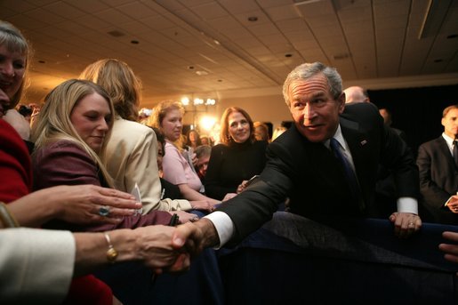 President George W. Bush reaches out for the hand of well-wisher after speaking Tuesday, Oct. 25, 2005, to the Joint Armed Forces Officers' Wives Luncheon at the Bolling Air Force Base Officer's Club in Washington, D.C. White House photo by Paul Morse