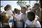 President George W. Bush greets local residents lined up at a food and water distribution center, Thursday, Oct. 27, 2005, in the hurricane damaged area of Pompano Beach, Fla. White House photo by Eric Draper