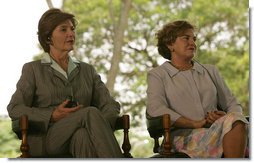 Mrs. Laura Bush and Mrs. Marisa Leticia da Silva listen to remarks by their husbands, during a joint statement at Granja do Torto, home of Brazil President Luiz Inacio Lula da Silva, Saturday, Nov. 6, 2005.  White House photo by Paul Morse