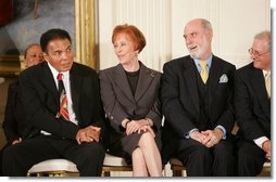 Boxing legend Muhammad Ali glances over to the President during the during the presentation of the Presidential Medal of Freedom in the East Room Wednesday, Nov. 9, 2005. President Bush awards the honor to 14 recipients during the ceremony.  White House photo by Paul Morse