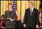 Carol Burnett jokes with President George W. Bush during the presentation of the Presidential Medal of Freedom to in the East Room Wednesday, Nov. 9, 2005. As a singer, dancer, comedienne, and actress, she has been one of America’s most cherished entertainers since her Broadway by in 1959. White House photo by Paul Morse